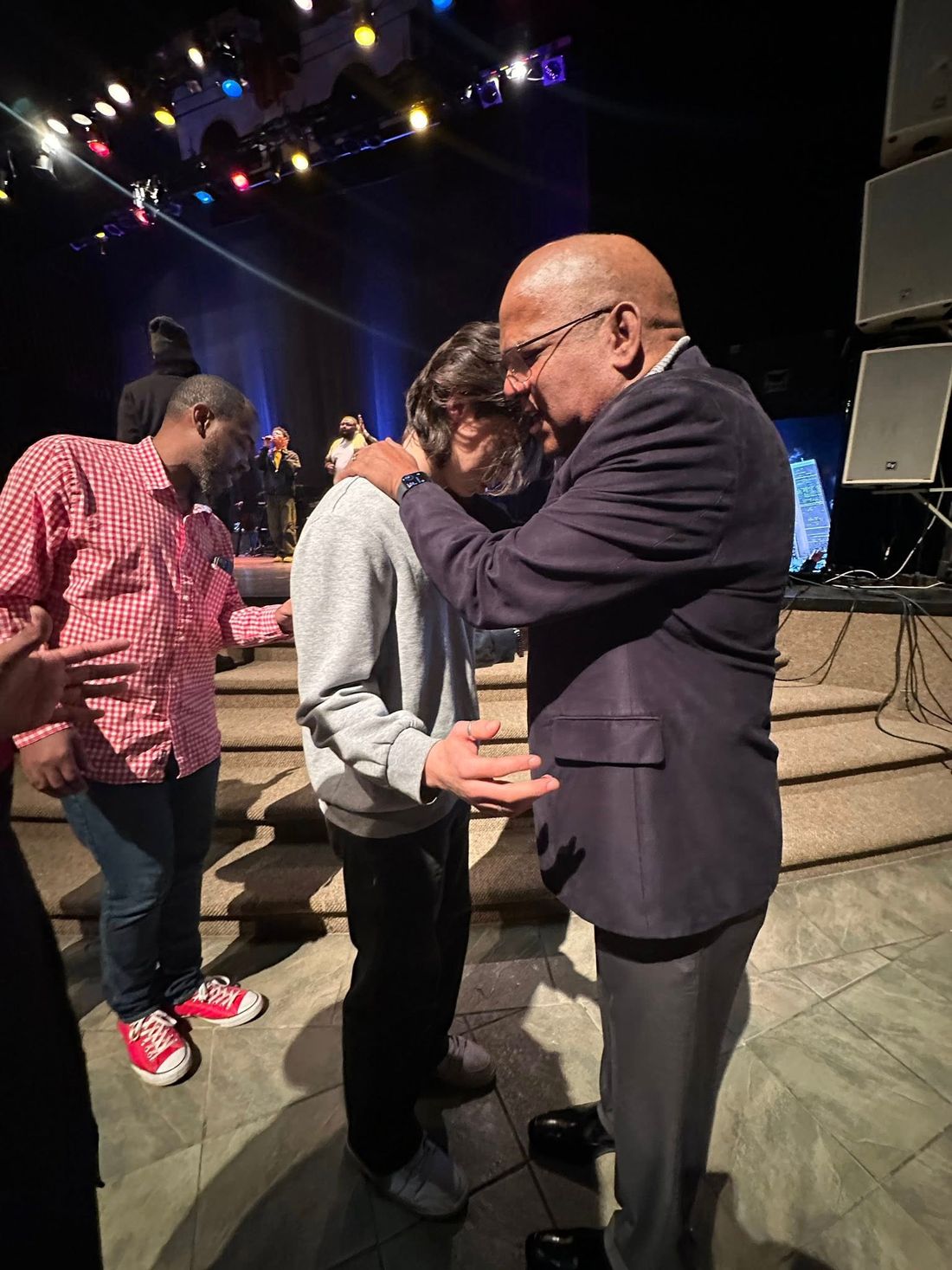 Apostle Stanford praying with a member