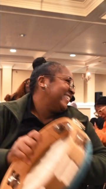 A worshiper smiling with a tambourine